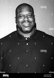 shaq in a polo shirt smileing in black and white